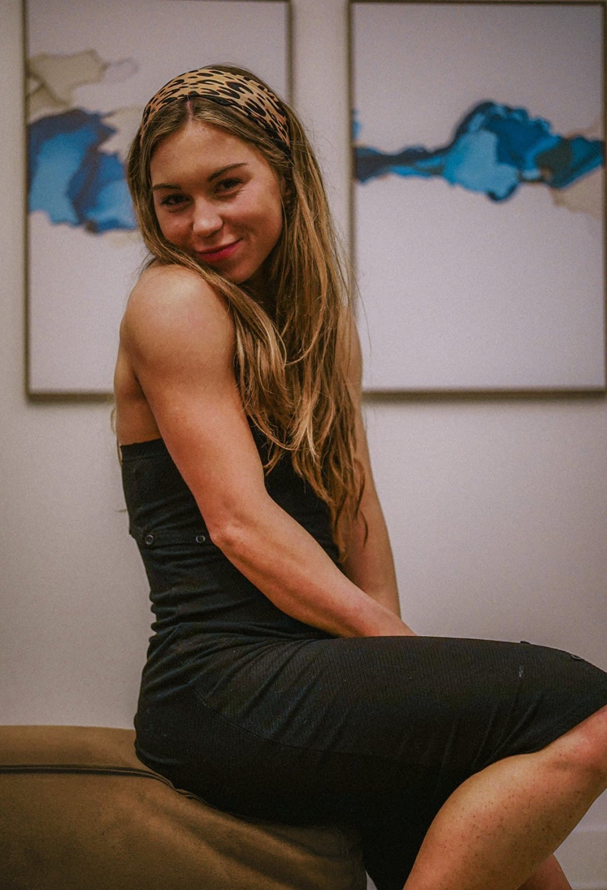 Danielle Kusenberger in a black dress and leopard headband, smiling