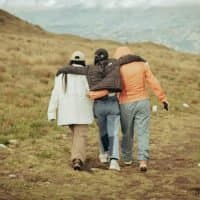 Three women walking a hillside trail together