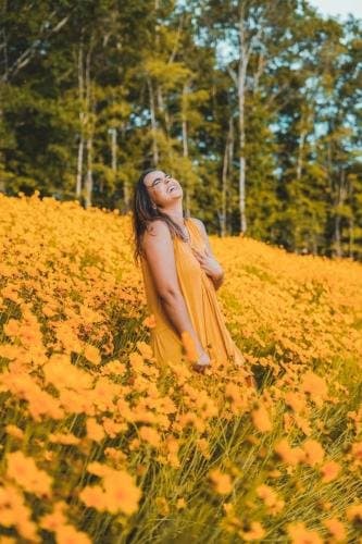 Empowerment photoshoot in a field of yellow flowers